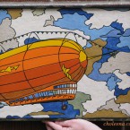 Zeppelin. Recycled paper-tile mosaic. 169 pieces. $265 tax-free. 16.75″Wx13.5″H (the flag is the Independence flag from the show Firefly)
